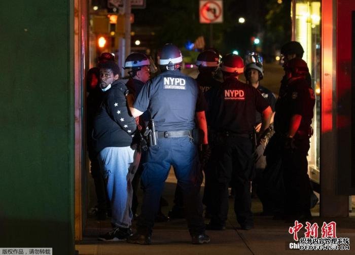 资料图：当地时间6月2日，美国纽约进入宵禁后，警察在街上拘捕了部分未执行规定的人。